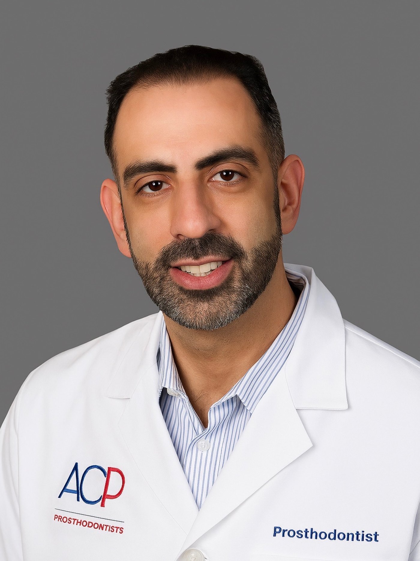 Dr. Jonathan Berkowitz, DMD, prosthodontist, wearing an American College of Prosthodontists coat